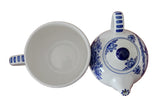 Ceramic teapot and cup with blue floral patterns on a wooden surface